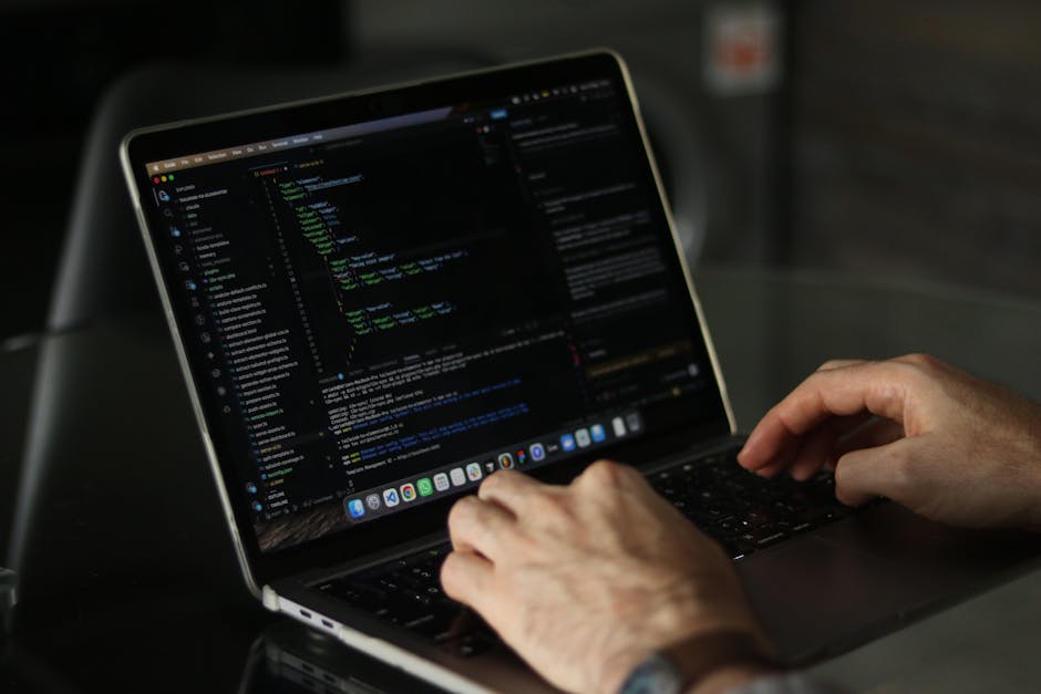 Photograph of a computer screen displaying HTML code with syntax highlighting, featuring tags related to image sources and alt text attributes, set against a dark background with multicoloured text. T