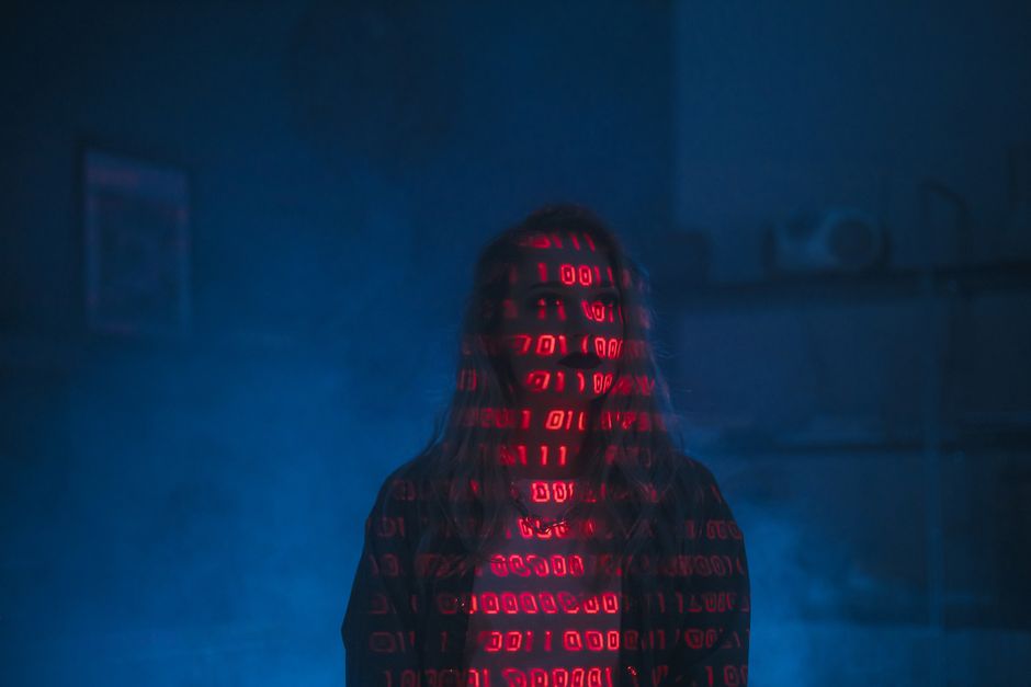 Close-up view of a computer screen displaying lines of programming code with various colors, including green, orange, blue, and white text on a black background. The code appears to be part of a softw